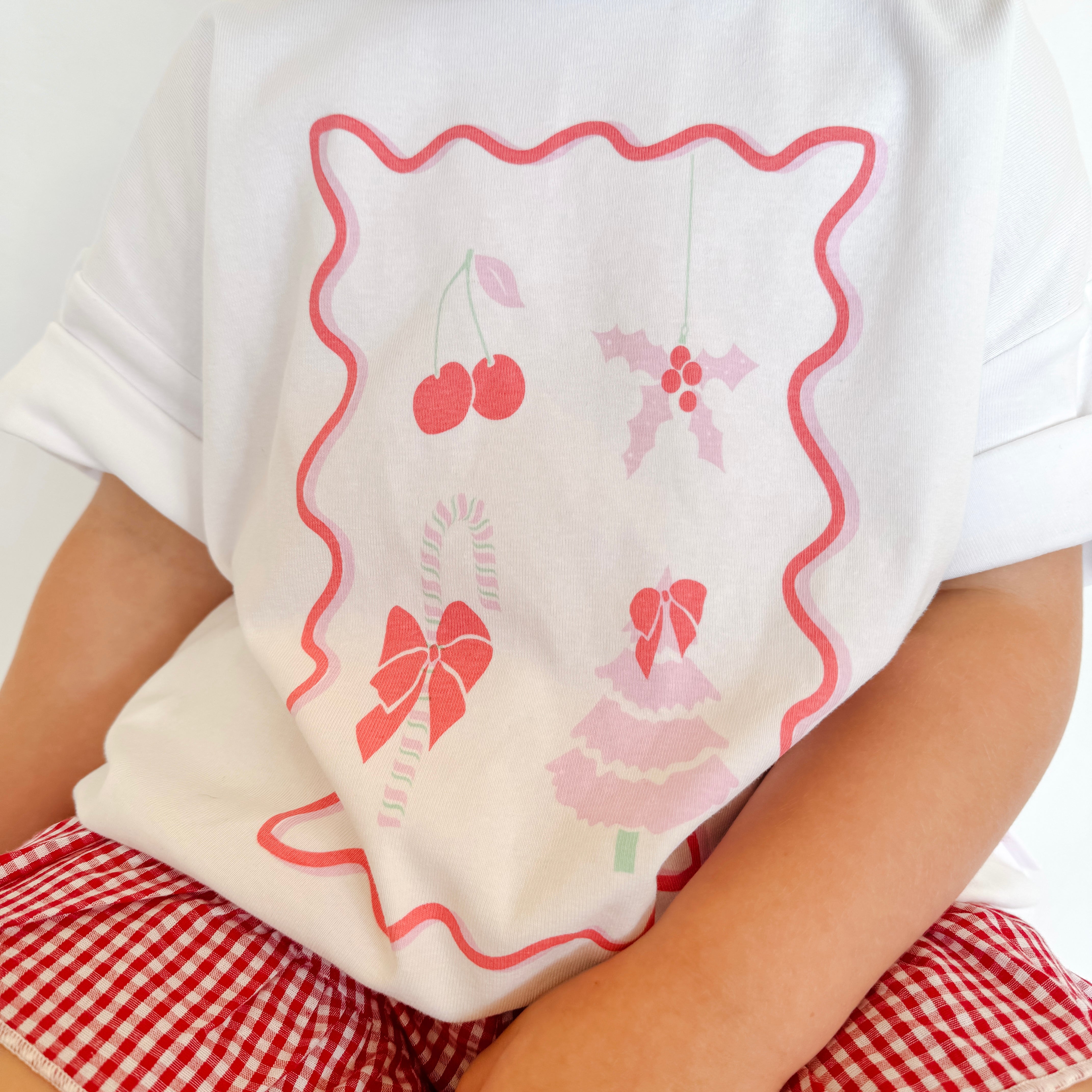 Rosie wearing Christmas stamp tee and cherry red gingham shorts