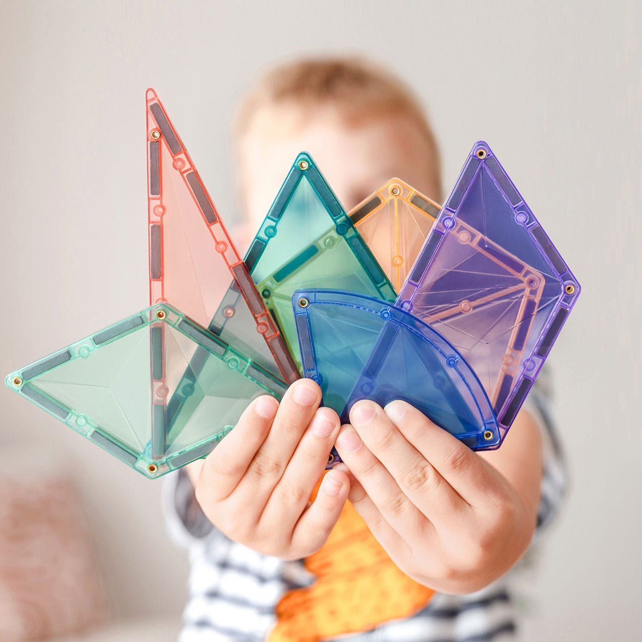Assorted Connetix pastel magnetic tile shapes including pentagons, triangles, and trapezoids