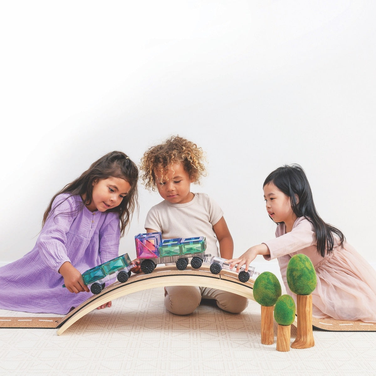 Children playing with Connetix Pastel Transport Pack – magnetic car and train pieces in action