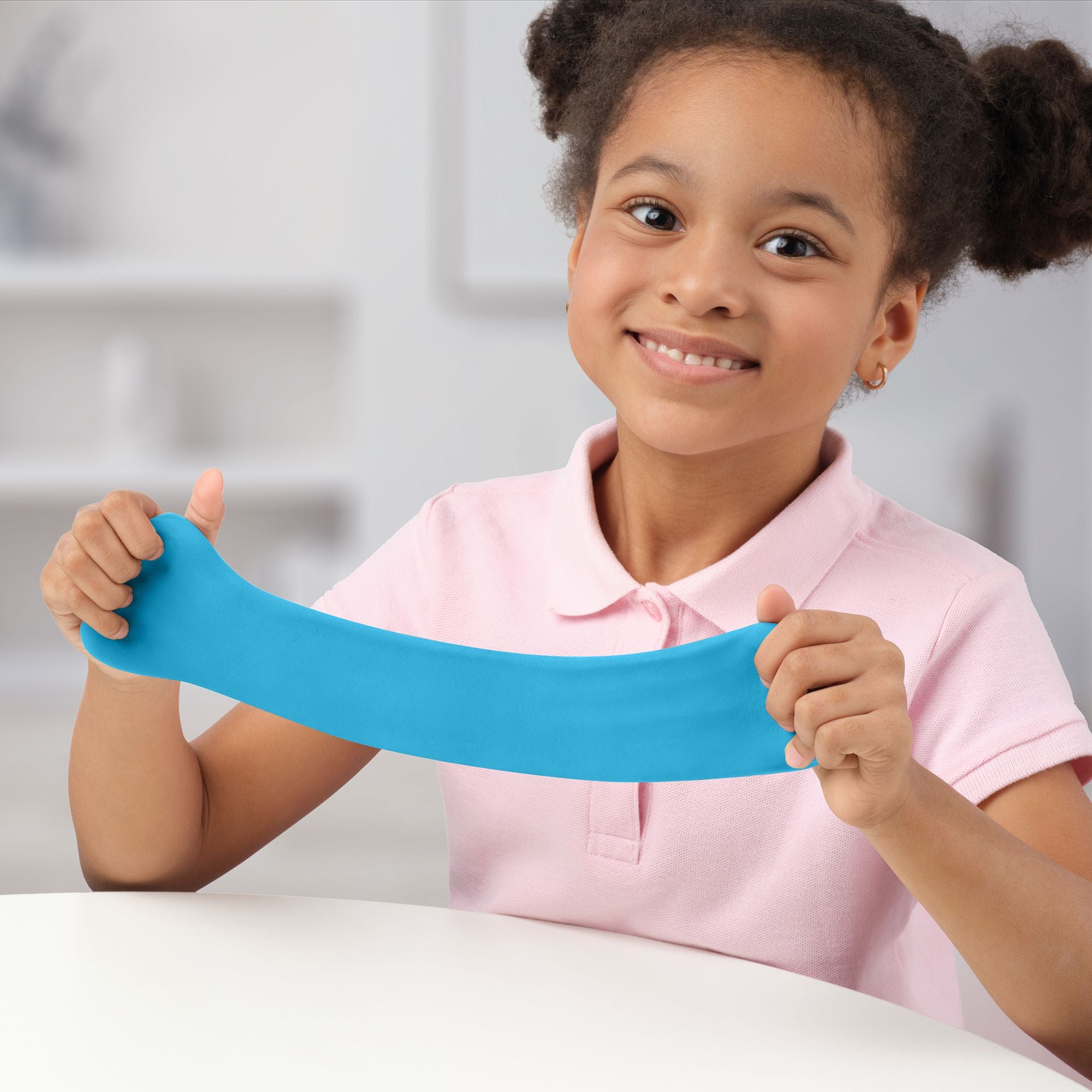 Young girl holding a blue hey clay