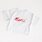White t-shirt with red 'Merci' text on a white background Cinnamon Baby White Fox & Co exclusive 