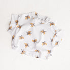 White baby t-shirt romper with crossiant pattern on a white background.  Cinnamon Baby Merci collection