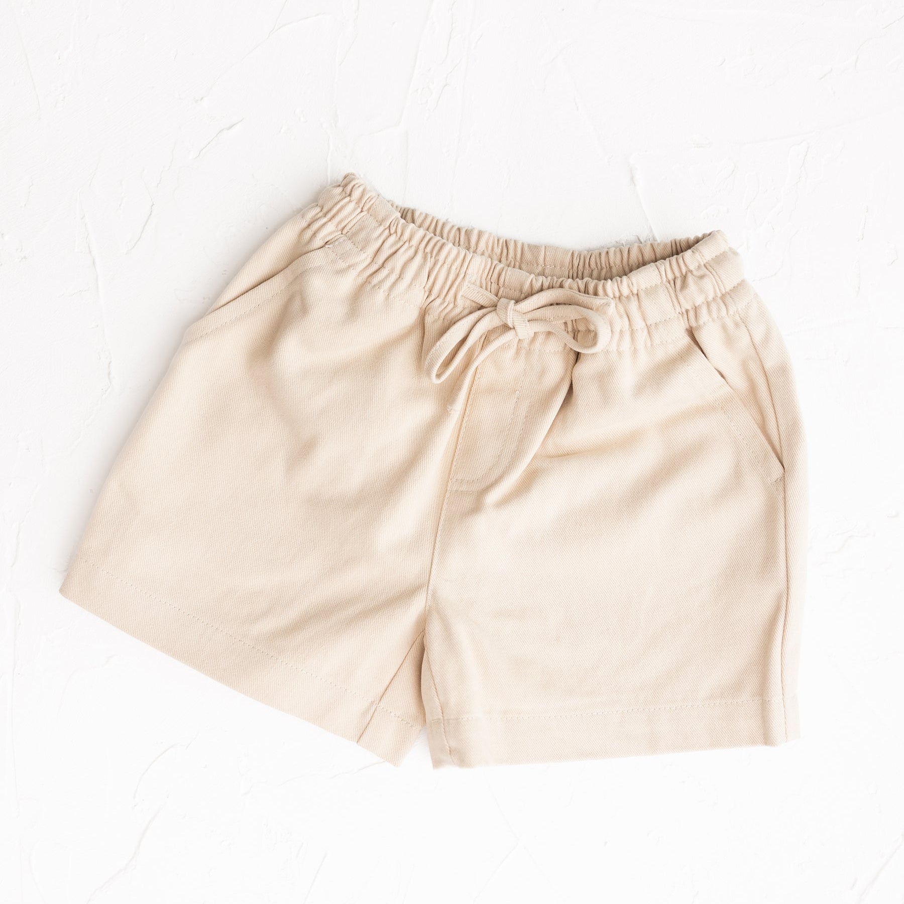 Beige shorts with drawstring on a white background by Cinnamon Baby for Merci Collection exclusive to White Fox & Co in NZ