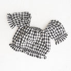 Black and white checkered outfit with ruffled sleeves on a white background
