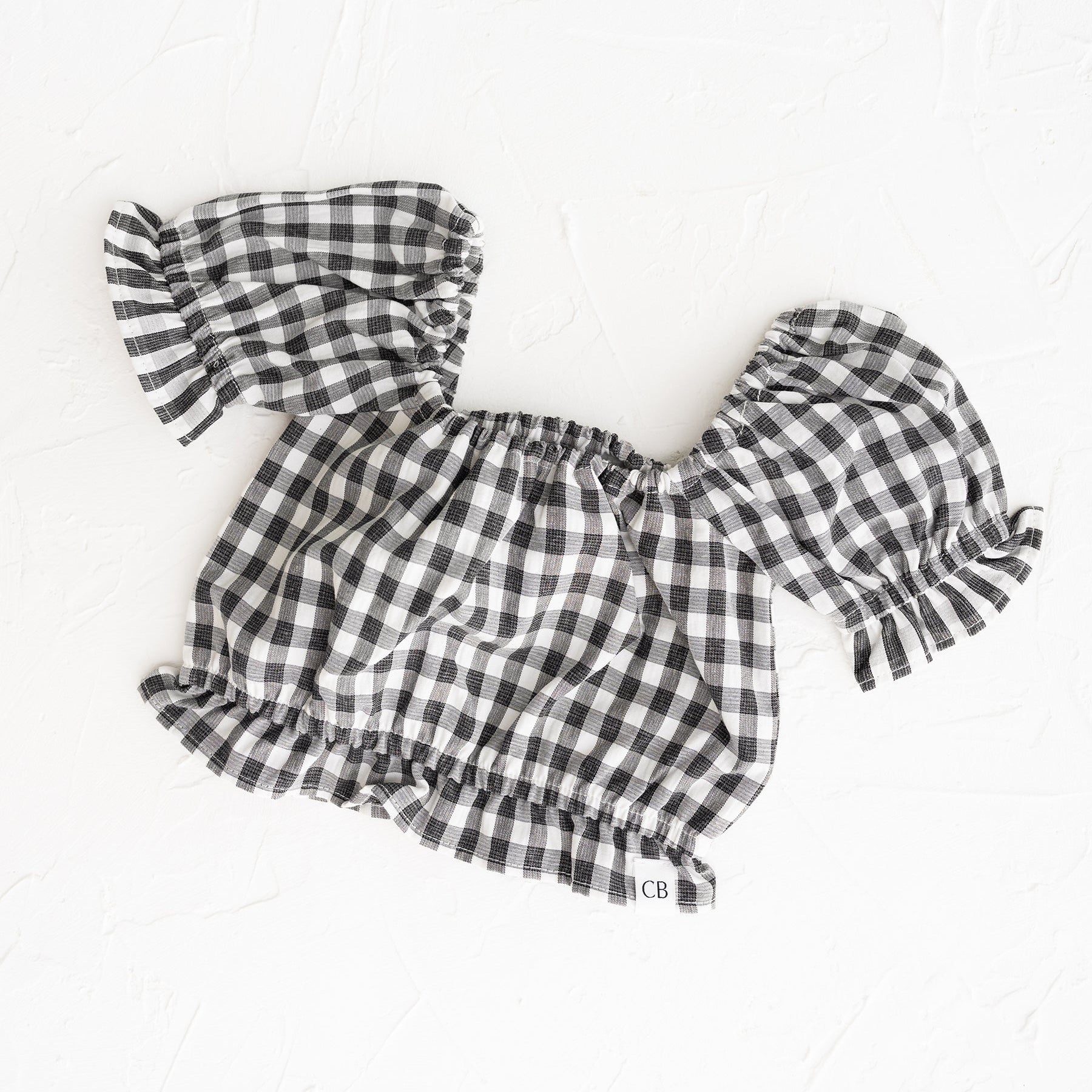 Black and white checkered outfit with ruffled sleeves on a white background