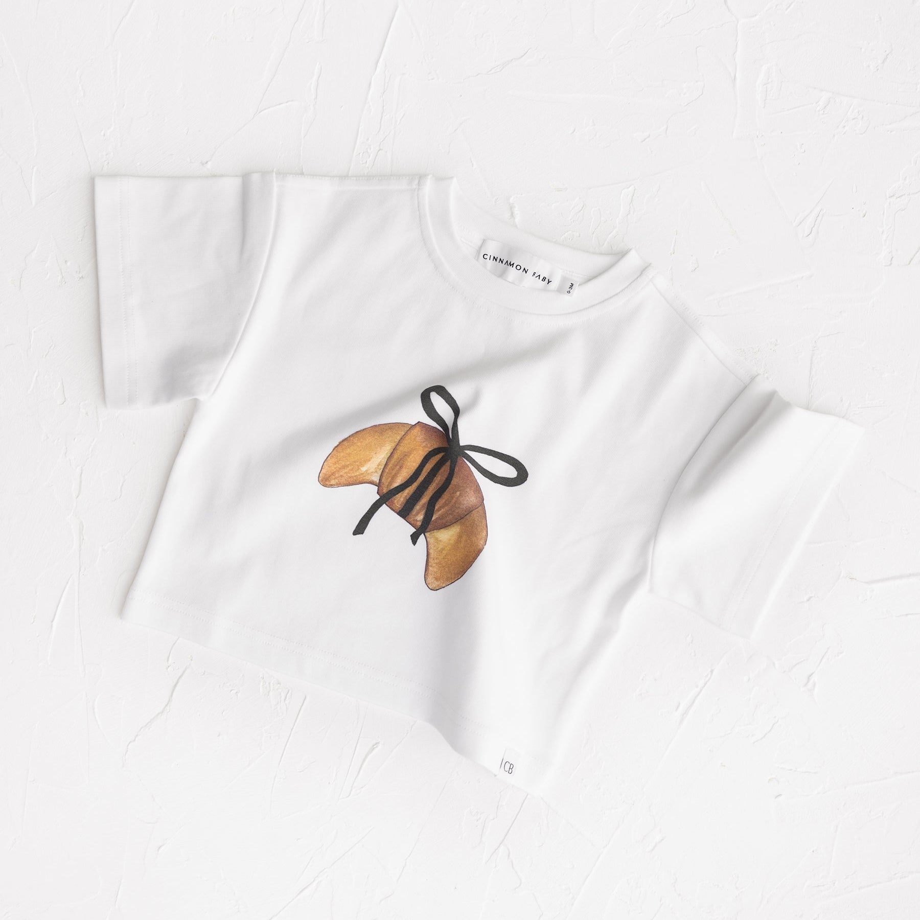 Cinnammon Baby Tee with Crossiant wrapped in ribbon print exclusive stockist White Fox & CDo in NZ