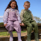 Child wearing Crywolf Rain Overalls Heather outdoors