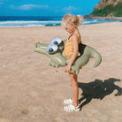 Child floating in a Sunnylife Cookie the Croc kiddy float in a pool