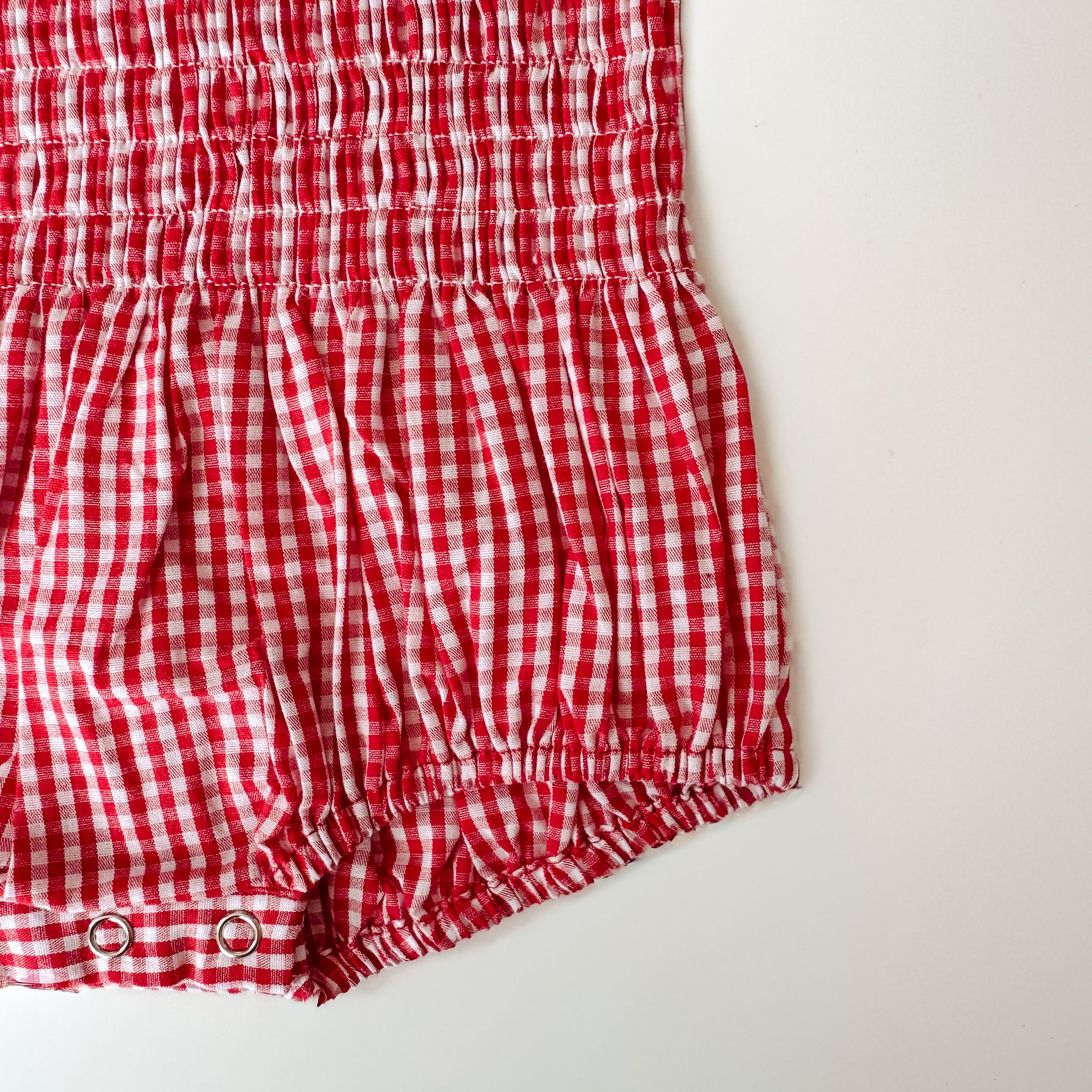 Cherry red shirred romper close up of snap crotch 