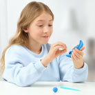 Young girl playing with a blue hey clay creation 