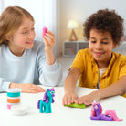 Two children playing with colorful hey clay unicorn set and toy unicorns on a table.
