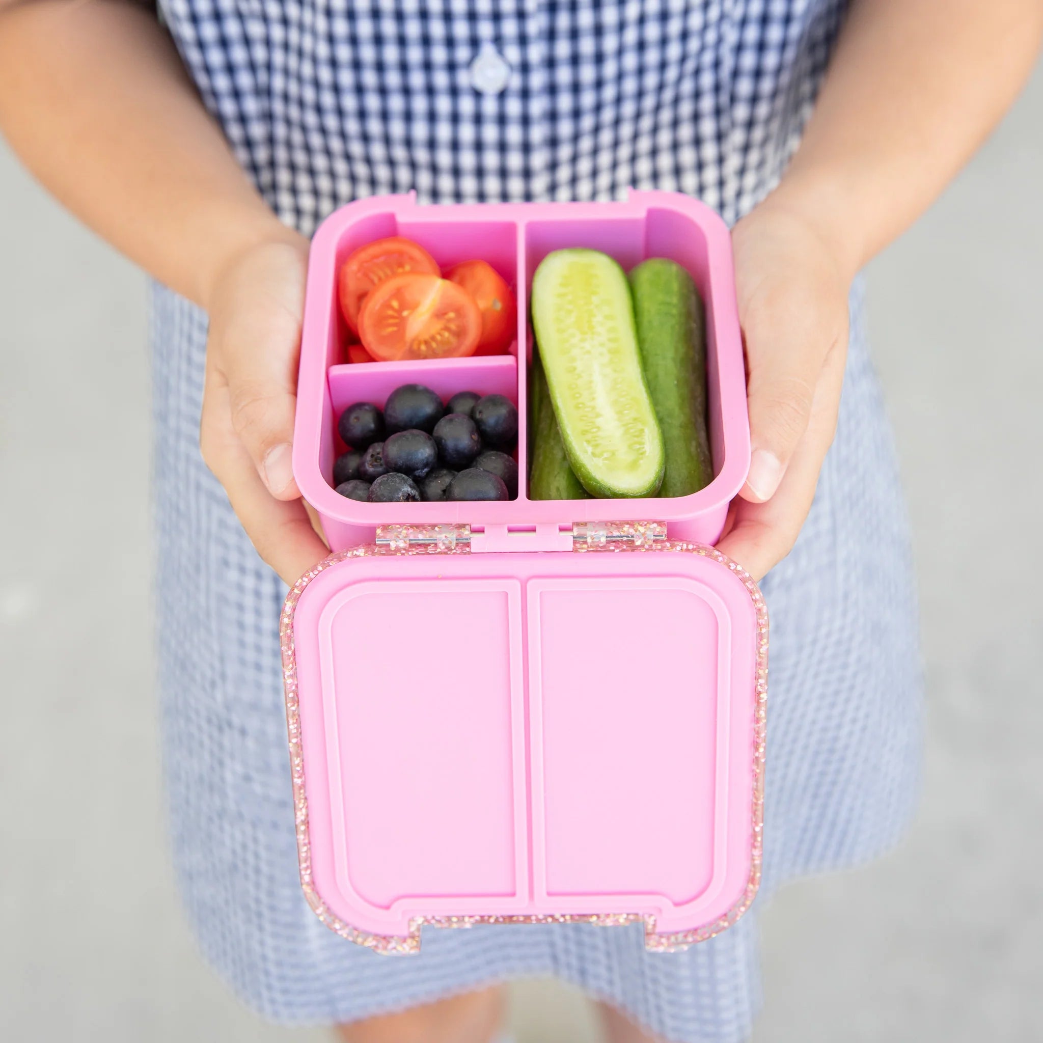 Child holding MontiiCo Bento Two in Floss Glitter – pink glitter lunchbox for school